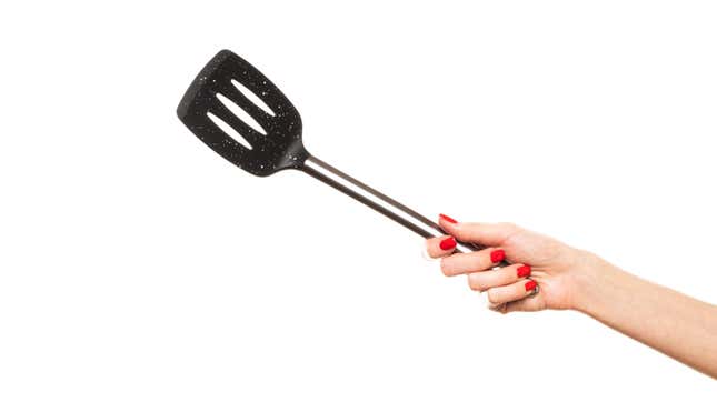 The Kitchen Tools That Deserve a Spot in Your Utensil Holder 3 Hand holding spatula in the air.