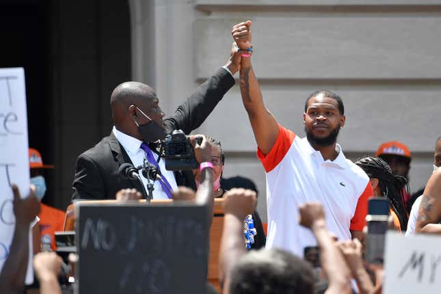 Attorney Benjamin Crump, left, holds up the hand of Kenneth Walker during a rally on the steps of the Kentucky State Capitol in Frankfort, Ky., on June 25, 2020. Walker, the boyfriend of Breonna Taylor who fired a shot at police as they burst through Taylor’s door the night she was killed, has settled two lawsuits against the city of Louisville, his attorneys said Monday, Dec. 12, 2022.