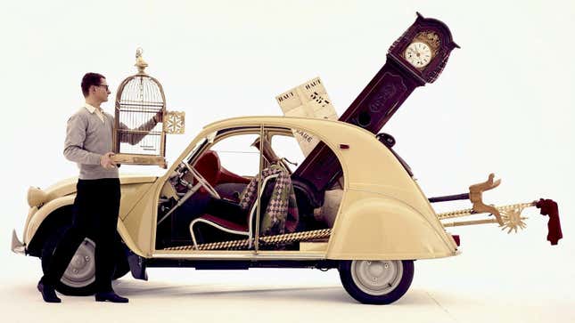 A photo of a white Citroën 2CV filled with stuff. 