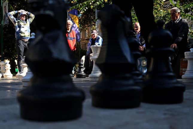 Large chess pieces sitting on a street.