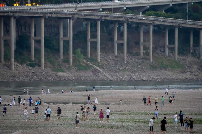 People walk in the dry riverbed of the Jialing River, a tributary of the Yangtze, on August 20.