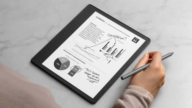 The Amazon Kindle Scribe on a marble countertop with a user holding a stylus in the right hand.