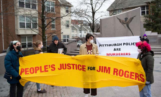 People stand at Freedom Corner before marching up Centre Avenue to demand justice for Jim Rogers, who died after being tased by Pittsburgh Police, on Sunday, Jan. 2, 2022, in the Hill District neighborhood of Pittsburgh, Pa.