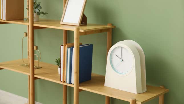 bookshelf with books and a clock