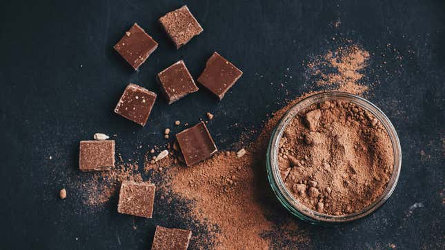 Dark chocolate squares next to bowl of cacao powder