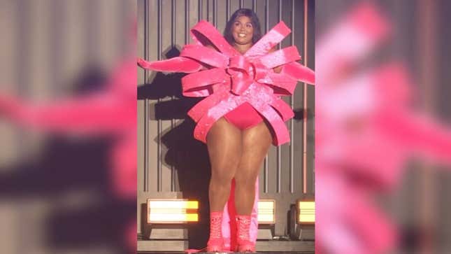 Lizzo smiles and poses on stage while wearing a Sailor Moon-inspired outfit.