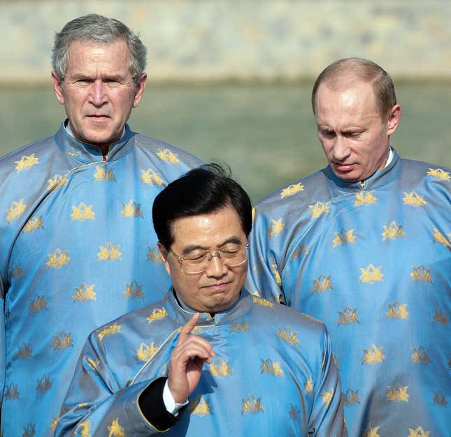Hanoi, VIET NAM: US President George W. Bush (L), Russian President Vladimir Putin (R) and Chinese President Hu Jintao (C), all wearing a Vietnamese 'ao dai' silk tunic, speak as they take part in the official photograph for the Asian Pacific Economic Cooperation (APEC) summit in Hanoi, Vietnam 19 November 2006.