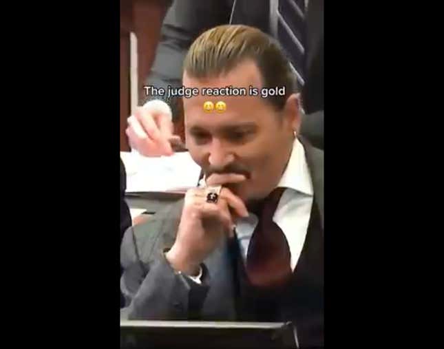 A screenshot of a laughing Johnny Depp during his trial against ex-wife Amber Heard is shown.