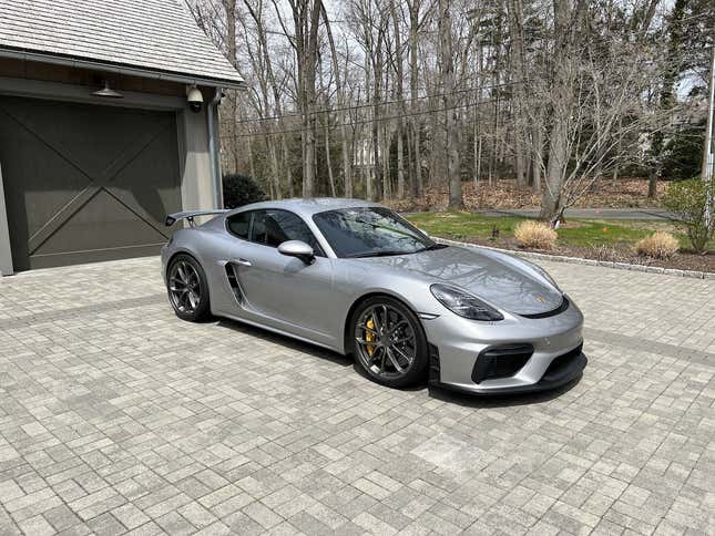A silver 2020 Porsche Cayman GT4 is parked on a very nice driveway