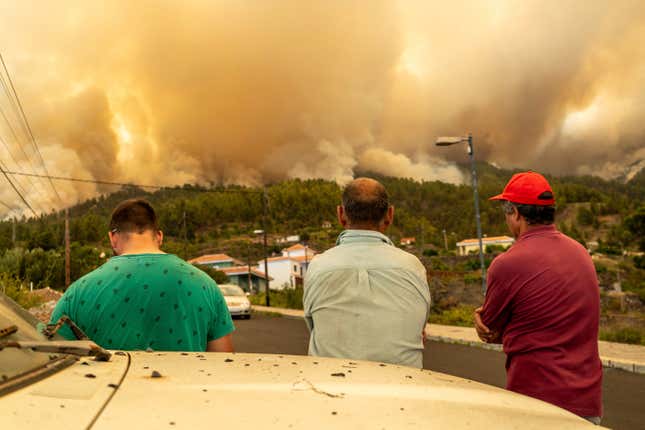 Local residents look on at a burning forest fire, near Puntagorda on the Canary Island of La Palma, Saturday, July 15, 2023. 