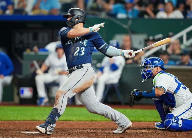 Aug 15, 2023; Kansas City, Missouri, USA; Seattle Mariners first baseman Ty France (23) hits a two-run single against the Kansas City Royals during the tenth inning at Kauffman Stadium.
