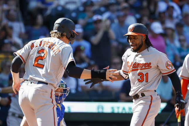 Aug 13, 2023; Seattle, Washington, USA; Baltimore Orioles center fielder Cedric Mullins (31) reacts with shortstop Gunnar Henderson (2) after hitting a two-run home run against the Seattle Mariners during the tenth inning at T-Mobile Park. Henderson scored a run on the hit.