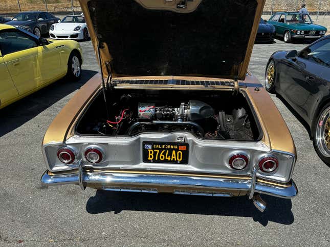 A gold turbocharged Chevy Corvair is parked in the Bring-A-Trailer lot at Laguna Seca