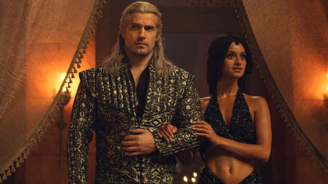 Henry Cavill as Geralt and Anya Chalotra as Yennefer in The Witcher Netflix series. He's wearing a fancy jacket while she's in a midriff-baring dress.