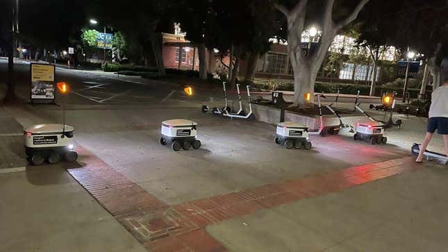 Imagen para el artículo titulado Se forma un atasco de robots repartidores por un patinete eléctrico mal estacionado