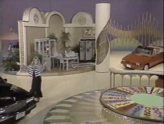 Vanna White invites the audience to take in the splendor of the Wheel Of Fortune set, unobstructed by a clumsy stand-up wheel.