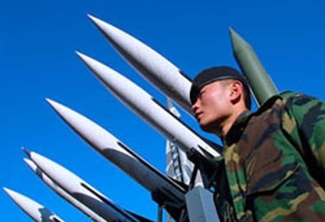 A North Korean soldier stands guard over missiles so advanced, Iraq is prohibited from possessing them.