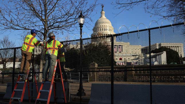 Workers put concertina razor wire along the top of the 8-foot ‘non-scalable’ fence that surrounds the U.S. Capitol 