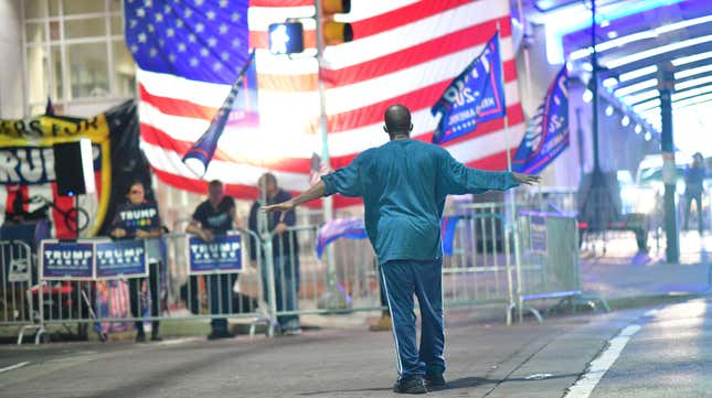 A man approaches supporters of President Donald Trump demonstrating outside of where votes were being counted six days after the general election on November 9, 2020 in Philadelphia.