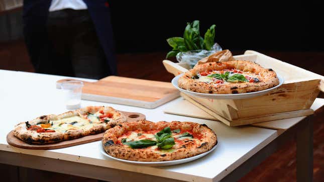 three neapolitan pizzas on a table