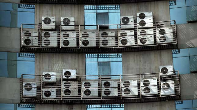 Air conditioners hang on the wall of an office building in Fuzhou, China.