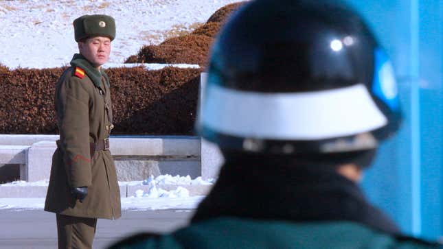 A North Korean soldier watches South Korean soldiers on January 29, 2003, as he stands at the site of the signing of the 1953 armistice. 