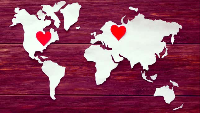 A cut-out of the continents with a red heart in the U.S. and one in Europe