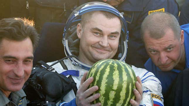 Russian cosmonaut Alexey Ovchinin holds a watermelon
