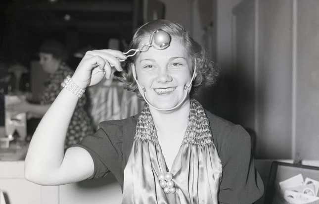 4/9/1938- Chicago, IL: A young woman demonstrates a ‘dimple’ machine at the Inventor’s Congress in Chicago.