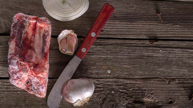 A frozen cut of meat on a rustic wood table