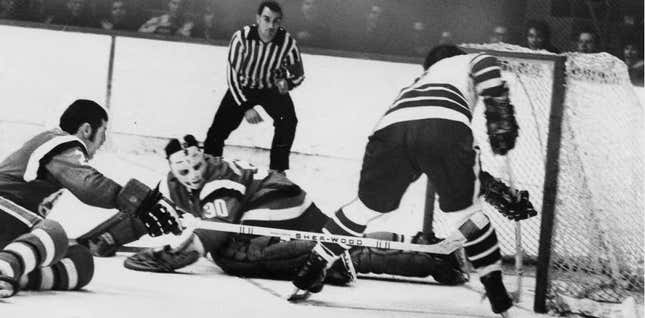 Mike Chernoff of the AHL Cleveland Barons scores against Providence Reds goalie Ross Brooks in a 1970 game.