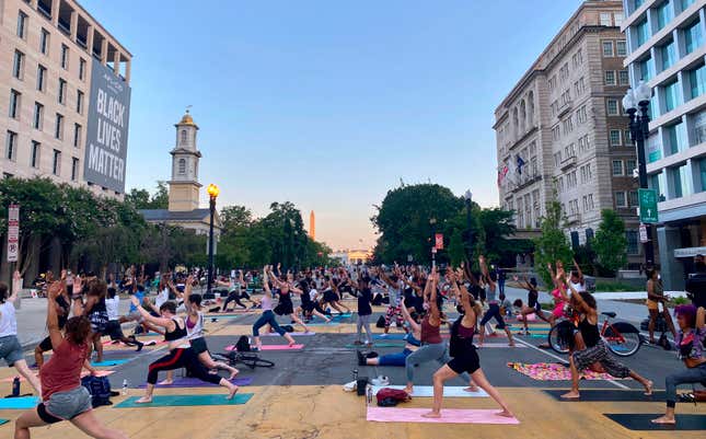 With the White House and Washington Monument off in the distance, D.C. protestors deal with their on-going PTSD by getting stretching out their mats along Black Lives Matter Plaza and doing some stress-relieving yoga poses.