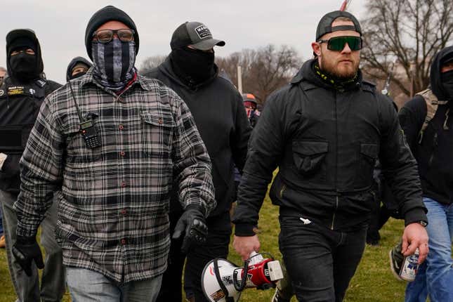 Proud Boys members Joseph Biggs, left, and Ethan Nordean, right with megaphone, walk toward the U.S. Capitol in Washington, in support of President Donald Trump.