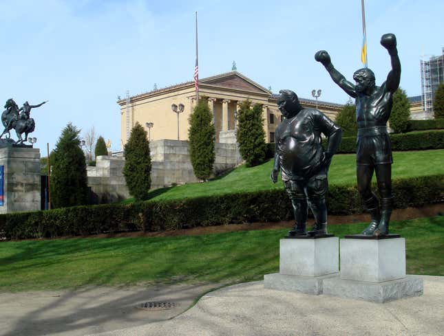 Image for article titled Philadelphia Museum Of Art Erects Statue Of Overweight Tourist Posing Next To Rocky Statue