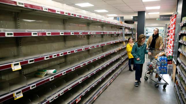 Grocery shoppers surrounded by empty shelves
