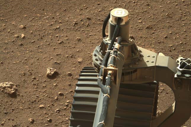 The rover’s front left wheel and some rocks. 