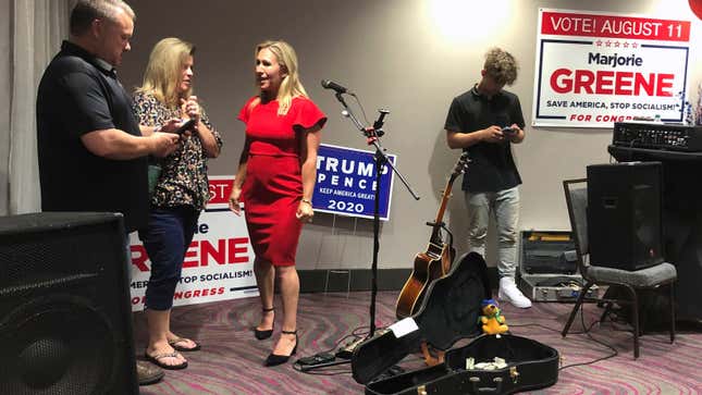 QAnon conspiracy theorist Marjorie Taylor Greene, seen in red, at an election event at Rome, Georgia in August 2020.
