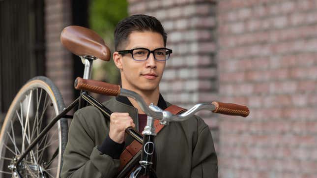 Man carrying bike while wearing Amazon's Echo Frames smart glasses.