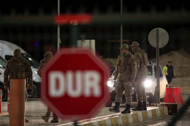 Turkish military and security personnel stand at the entrance of the Copler gold mine near Ilic village, eastern Turkey, Tuesday, Feb. 13, 2024. A huge landslide hit a gold mine in eastern Turkey on Tuesday, trapping at least nine workers underground, officials said. (Ugur Yildirim/Dia images via AP)