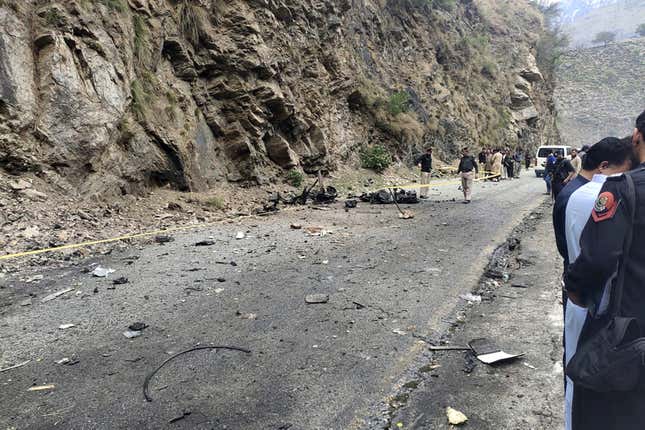 Police officers examine the site of suicide bombing at a highway in Shangla, a district in the Pakistan&#39;s Khyber Pakhtunkhwa province, Tuesday, March 26, 2024. A suicide bomber in northwest Pakistan rammed his explosive-laden car into a vehicle Tuesday, killing five Chinese nationals and their Pakistani driver, police and government officials said. (AP Photo)