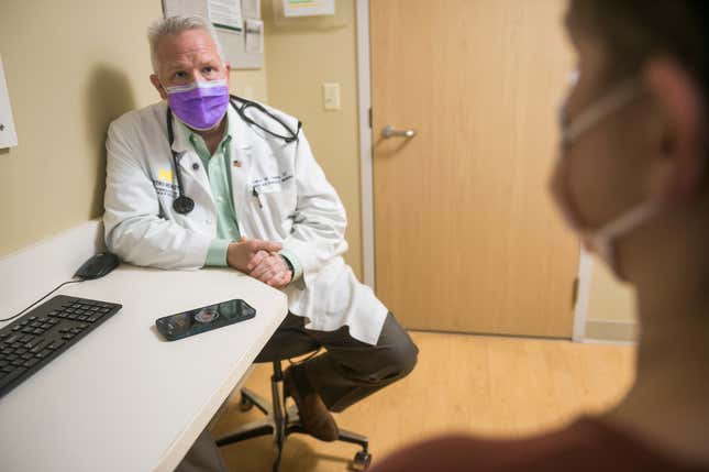 In this photo provided by University of Michigan Health-West, Dr. Lance Owens, chief medical information officer at the university, demonstrates the use of an AI tool on a smartphone in Wyoming, Mich., on Sept. 9, 2021. The software listens to a doctor-patient conversation, documents and organizes it to write a clinical note. (University of Michigan Health-West via AP)