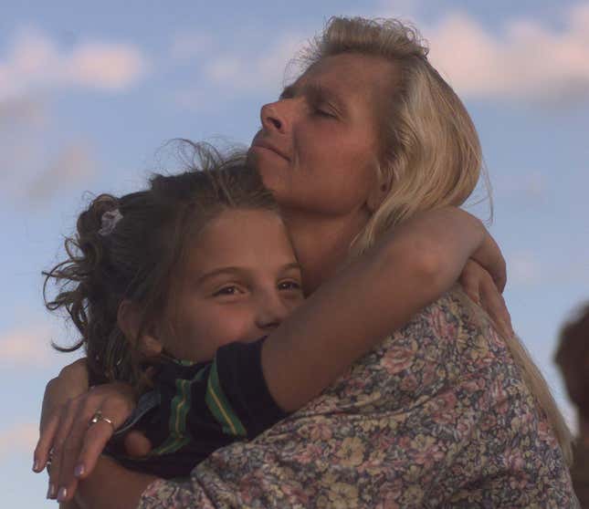  Jenna Stock and her mother Julie Stock share a hug while listening to music by Shawn Colvin at Lilith Fair in 1997.