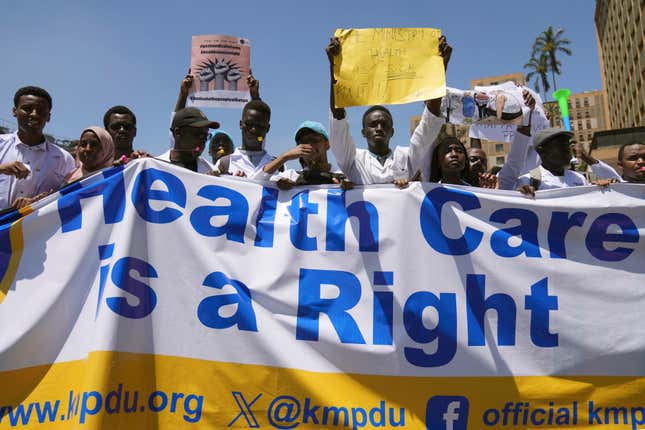 Doctors and other medical staff take part in a protest, in downtown Nairobi, Kenya, Friday, March 22, 2024. Hundreds of Kenyan doctors have protested in the streets demanding better pay and working conditions in an ongoing nationwide strike that has entered its second week. The doctors carried placards and chanted against the Kenyan government on Friday, saying it had failed to implement a raft of promises, including a collective bargaining agreement signed in 2017 after a 100-day strike during which people died from lack of care. (AP Photo/Brian Inganga)