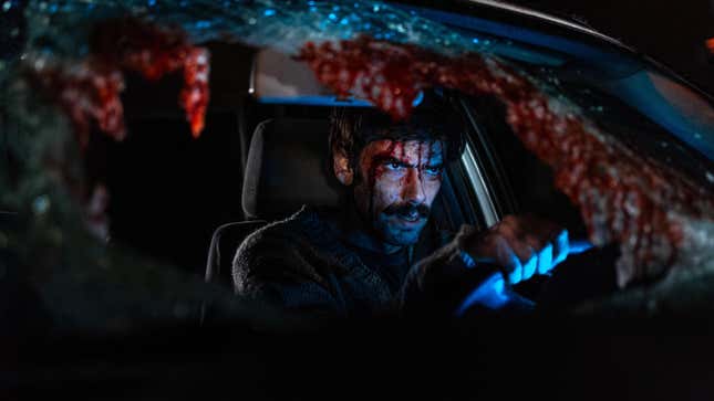 A man in a crashed car with a bloody face