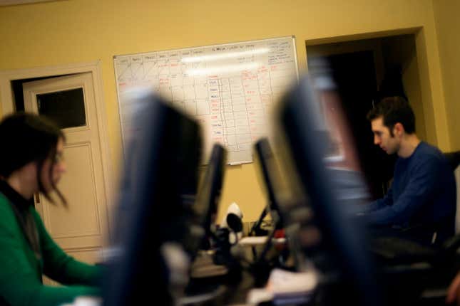 FILE - A billboard with working schedules hangs from the wall as Mar Parreno, left, and Mario Perez, two of the founders of the Factoria 5 digital design company, work in their office in Madrid, Monday, Feb. 25, 2013. The parties forming Spain’s acting government said Tuesday, Oct. 24, 2023, they will push for a 37½-hour workweek as part of an agreement the coalition partners struck as they try to remain in power following an inconclusive election in July. Spain has had a 40-work week for the past two decades. (AP Photo/Daniel Ochoa de Olza, File)