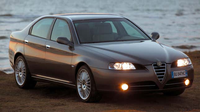 A photo of a grey Alfa Romeo parked on a beach. 