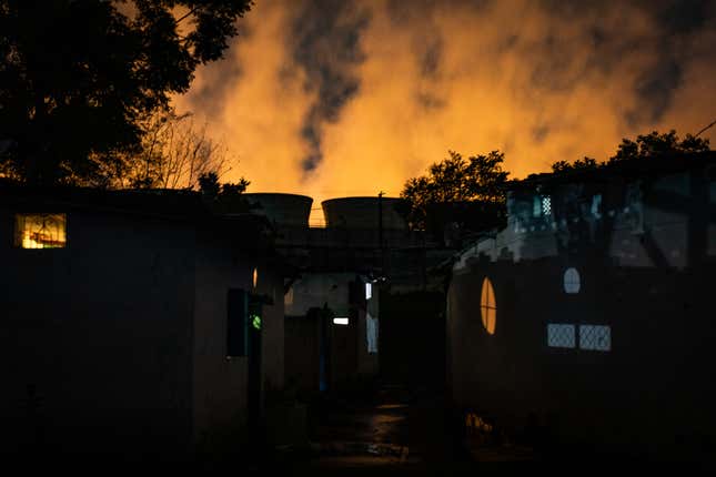 The cooling towers of the Dr Shyama Prasad Mukherjee Thermal Power Station as seen from the Patharripara Basti neighbourhood in Korba, Chhattisgarh, India.
