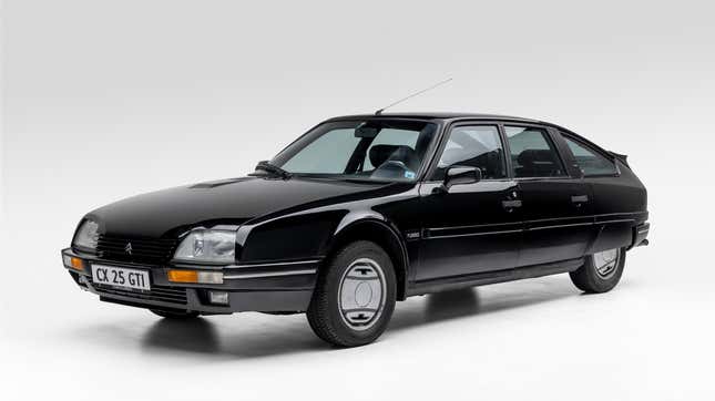 A black Citroen CX in a studio from the front three quarters angle