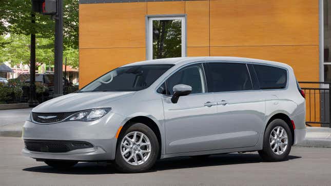 Una Chrysler Voyager gris estacionada frente a un edificio.