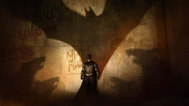 Batman stands in front of a concrete wall. 